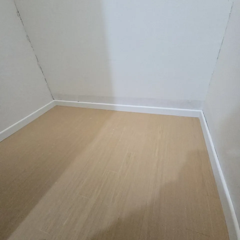 화성 몰딩교체 걸레받이 설치를 마친 방 전체와 나무색 바닥