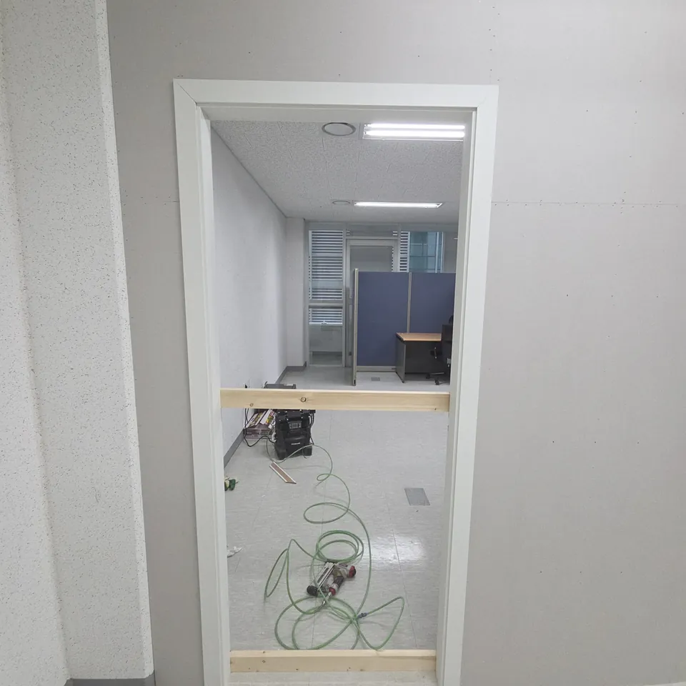 화성 몰딩교체 문선을 두른 출입구 안쪽에 임시 목재와 전선이 놓인 모습